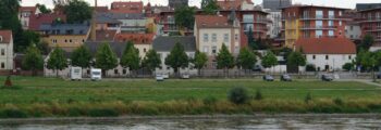 Vue panoramique Roanne, rivière calme, bateaux à quai, journée ensoleillée.