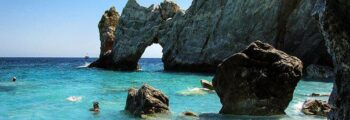 Vue panoramique sur la plage avec des eaux turquoise et des collines.